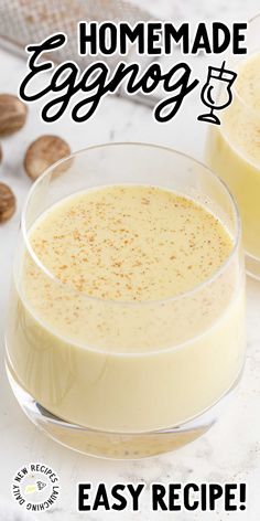 two glasses filled with eggnog sitting on top of a table next to nuts