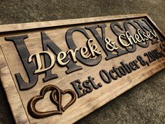 a wooden sign that says derek & chelsea, and has two hearts carved on it