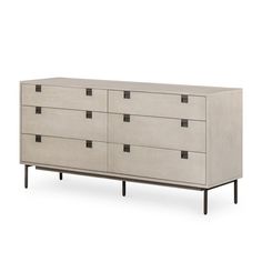 a white dresser with black handles and drawers