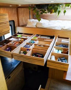 an open drawer on the inside of a camper with lots of items in it