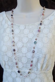 "This popular style necklace is very versatile and can be worn in three ways: simply as a long single-strand necklace, doubled to appear as a double-strand necklace, or hooked mid-way to appear like a lariat necklace (see images). This is a great piece to layer with other pieces. This stunning long strand necklace features beautiful Tourmaline natural stones and crystals. Great for the office or every-day wear. This piece is finished with a simple lobster claw closure and has my signature logo t Long Necklace Outfit, Popular Jewelry Trends, Ruby Jewelry Necklaces, Necklace Outfit, Long Statement Necklace, Long Silver Necklace, Long Beaded Necklace, Jewelry Beaded, Ruby Jewelry