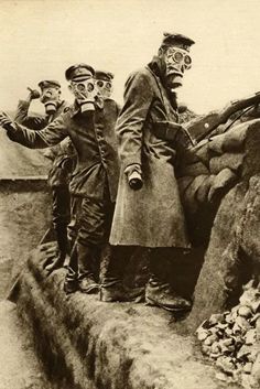 an old black and white photo shows men in gas masks standing on a rock wall