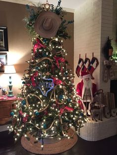 a decorated christmas tree in the corner of a room with stockings and hats on it