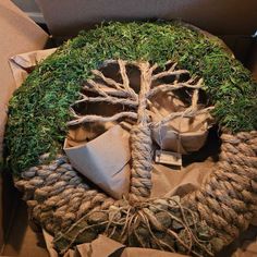 a tree made out of rope and other items in a cardboard box on the ground