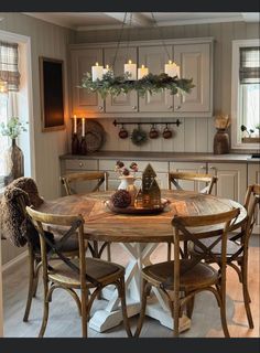 a kitchen table with chairs around it and candles on the wall behind it in front of an oven