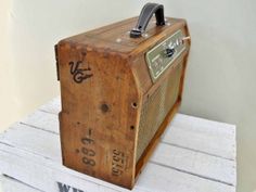 an old wooden radio sitting on top of some white books with numbers and symbols painted on it