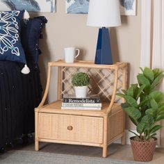 a table with a plant and some books on it next to a bed in a room