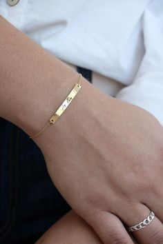 "This bracelet is the is the perfect heirloom piece. A bar charm is laser engraved with your handwriting for the perfect keepsake. Bar charm is stainless steel and plated in 18K gold. Bracelet requires little to no maintenance because stainless steel does not tarnish. Back of bracelet has three loops for attachment at 6\", 6.5\" and 7\". Details * Material - stainless steel * Bar measures 4mm by 35mm * total bracelet length is 7\" with clasp at 6\", 6.5\" and 7\" for the perfect fit. After you c Engraved Name Bracelet For Friendship, Minimalist Engraved Name Bracelet For Friendship, Minimalist Engraved Charm Bracelet For Friendship, Nameplate Bracelets With Engraving Option For Everyday, Gold Stamped Bracelet For Everyday, Everyday Nameplate Bracelets With Engraving Option, Personalized Rectangular Jewelry For Friendship, Rectangular Engraved Bracelets For Everyday, Everyday Engraved Name Bracelet In Rectangular Shape