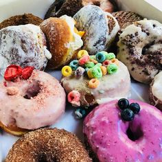 a box filled with lots of different flavored donuts