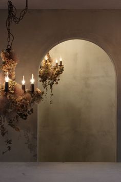 a chandelier with flowers hanging from it's sides in front of a mirror