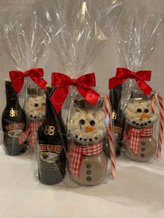 four bottles of booze and marshmallows are wrapped in cellophane to look like snowmen