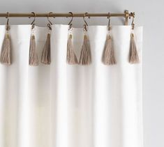 four tasselled curtains hanging on a curtain rod