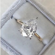 a pear shaped diamond ring in a box