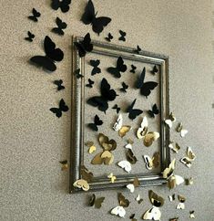 there are many butterflies flying in the air next to a framed artwork piece on the wall