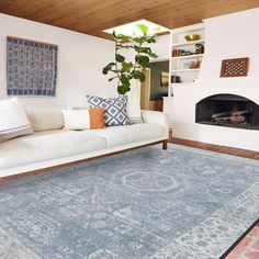 a living room filled with furniture and a rug on top of a hard wood floor