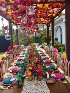 an image of a long table set up for a party with colorful decorations on it