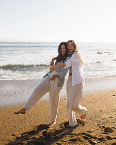 two women on the beach hugging each other