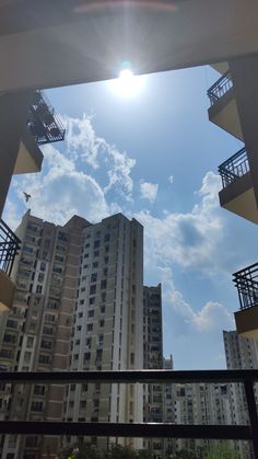 the sun shines brightly in front of some tall buildings with balconies and balconies