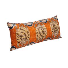 an orange and blue pillow with tiger designs on it's side, against a white background