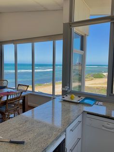 a kitchen with an island and large windows overlooking the ocean