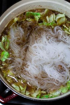 there is noodle soup in the pot on the stove