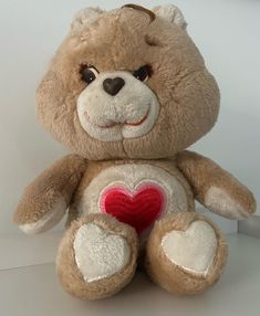 a brown teddy bear with a heart on its chest