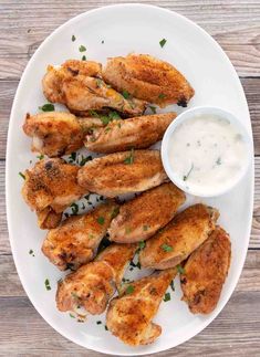 chicken wings with ranch dressing on a white plate