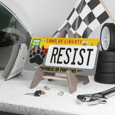 a license plate with a paw on it next to some tools and a helmet sitting on a table