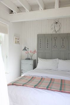 a bed with white sheets and pillows in a room