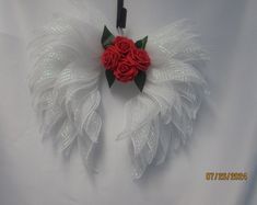 a red rose and white feather corsage