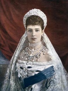 an old fashion portrait of a woman wearing a white dress and tiara with blue ribbon around her neck