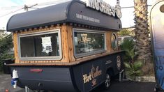 a food truck is parked on the side of the road with palm trees in the background