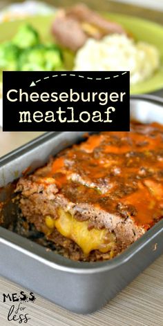 a meatloaf with cheese and sauce in a metal pan on a wooden table