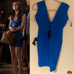 a blue dress hanging on the wall next to a woman's purse