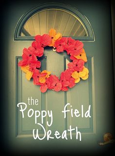 the poppy field wreath is hanging on the front door