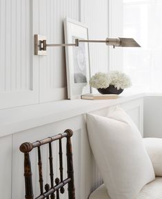 a room with white walls and pillows on the floor, along with a chair in front of it