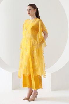 Canary yellow three fourth sleeves kaftan in organza base with all over blossom thread work and pearls embellishments. Paired with matching straight pant. 
Components: 2
Pattern: Embroidery
Type Of Work: Thread Work, Pearls
Neckline: Round 
Sleeve Type: Three Fourth
Fabric: Organza
Color: Yellow
Other Details: 
Asymmteric hem kaftan
Floral cut work hem kaftan
Model height: 5ft 8inches
Length:
Kaftan: 42 inches
Pant: 40 inches
Occasion: Sangeet, Mehendi and Haldi - Aza Fashions Embroidery Thread Work, Organza Embroidery, Pant For Women, Pattern Embroidery, Canary Yellow, Thread Work, Cut Work, Straight Pants, Embroidery Thread