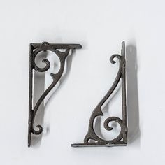 two metal brackets on a white surface one has a letter z and the other has a capital