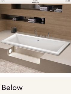 a bathtub sitting on top of a white counter next to a sink in a bathroom