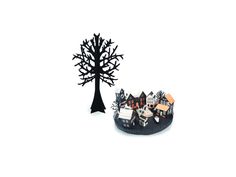 a paper cut out of a tree with houses on it and a house in the background