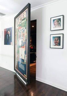 an open door leading into a room with pictures on the wall and wood floors in front of it