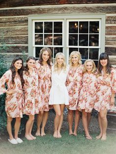 a group of women standing next to each other wearing matching robes and smiling at the camera