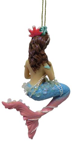 a mermaid ornament hanging from a string