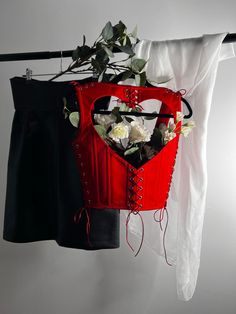 a red bag with flowers in it hanging on a clothes line