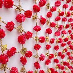 red and gold wall hangings with flowers on them, in the shape of pom - poms