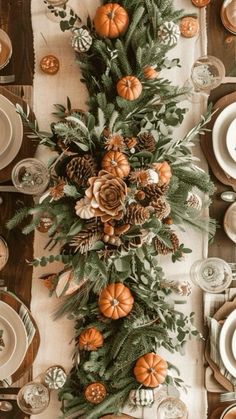 the table is set with white plates, silverware and orange pumpkins on it