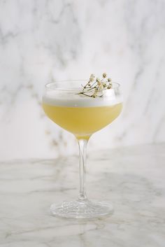 a drink in a wine glass on a marble table