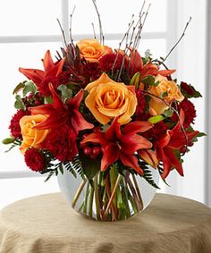 a vase filled with red and orange flowers