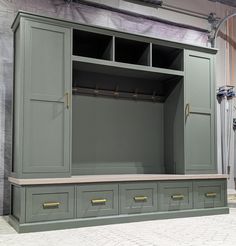 a large green cabinet with two doors and some drawers on the bottom one is open