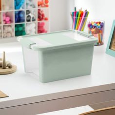 a white desk topped with lots of crafting supplies on top of a table next to a framed photo